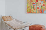 This inviting corner features a stylish lounge chair with a plush sheepskin throw and a complementary leather ottoman, perfect for creating a cozy reading nook.