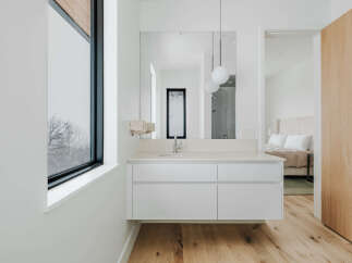 Experience modern luxury in this bathroom featuring a sleek floating vanity with ample storage and a minimalist aesthetic.
