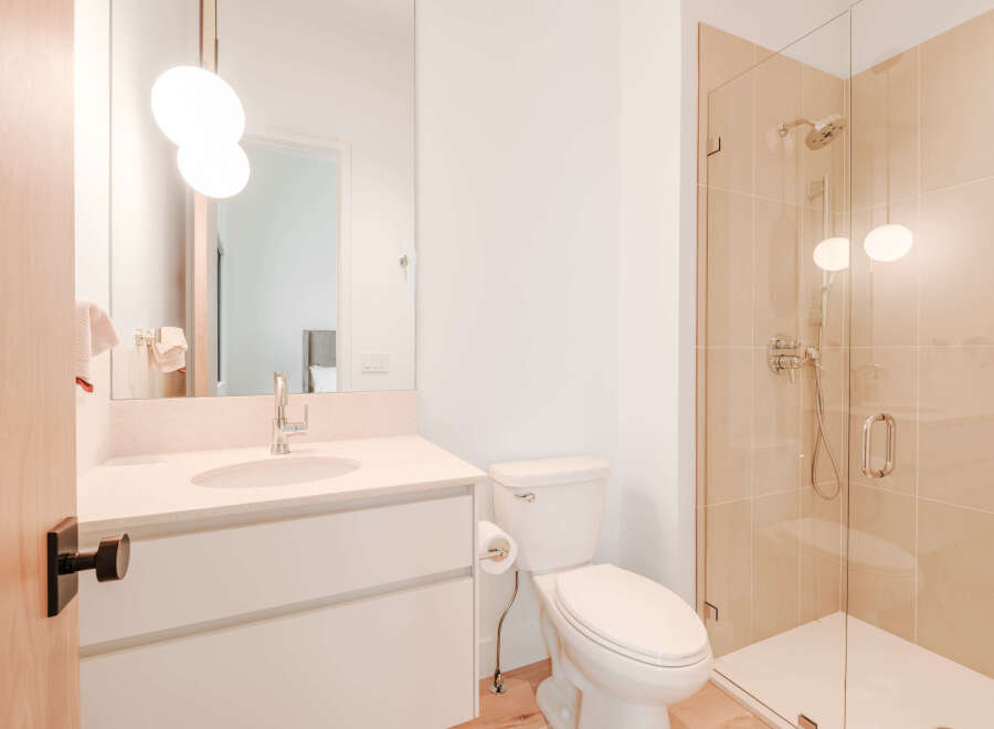 Experience modern luxury in this beautifully appointed bathroom, featuring a sleek vanity with a stone countertop and a stylish chrome faucet.