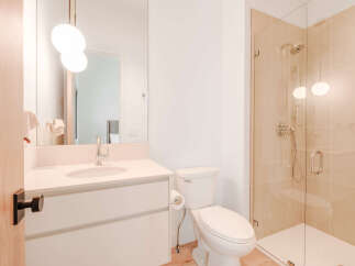 Experience modern luxury in this beautifully appointed bathroom, featuring a sleek vanity with a stone countertop and a stylish chrome faucet.