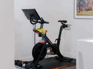 Elevate your fitness routine in this dedicated home gym space, featuring a top-of-the-line Peloton bike and adjustable dumbbells for a complete workout.
