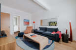 This stylish living room features a deep navy sofa complemented by a warm tan recliner and a unique woven coffee table.