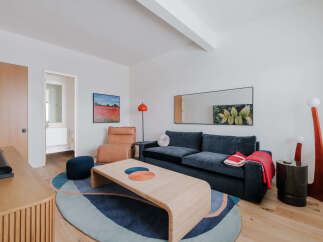 This stylish living room features a deep navy sofa complemented by a warm tan recliner and a unique woven coffee table.