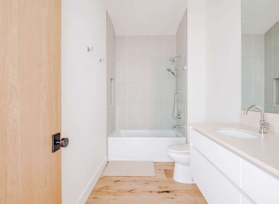 Experience modern comfort in this pristine bathroom, featuring a sleek vanity with an undermount sink and a chrome faucet.