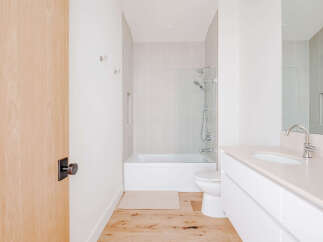 Experience modern comfort in this pristine bathroom, featuring a sleek vanity with an undermount sink and a chrome faucet.