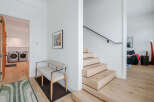 Step into this modern home featuring a sleek floating staircase with natural wood treads and a minimalist black handrail.