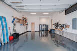 This spacious garage offers ample storage solutions, including wall-mounted shelving for lumber and tools, and a dedicated bike rack.