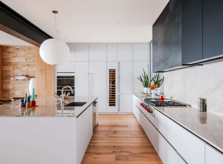 Experience modern luxury in this stunning kitchen, featuring sleek white cabinetry, a sophisticated marble island, and a professional-grade gas range.