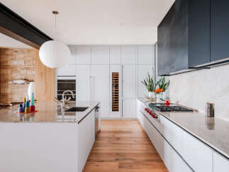 Experience modern luxury in this stunning kitchen, featuring sleek white cabinetry, a sophisticated marble island, and a professional-grade gas range.