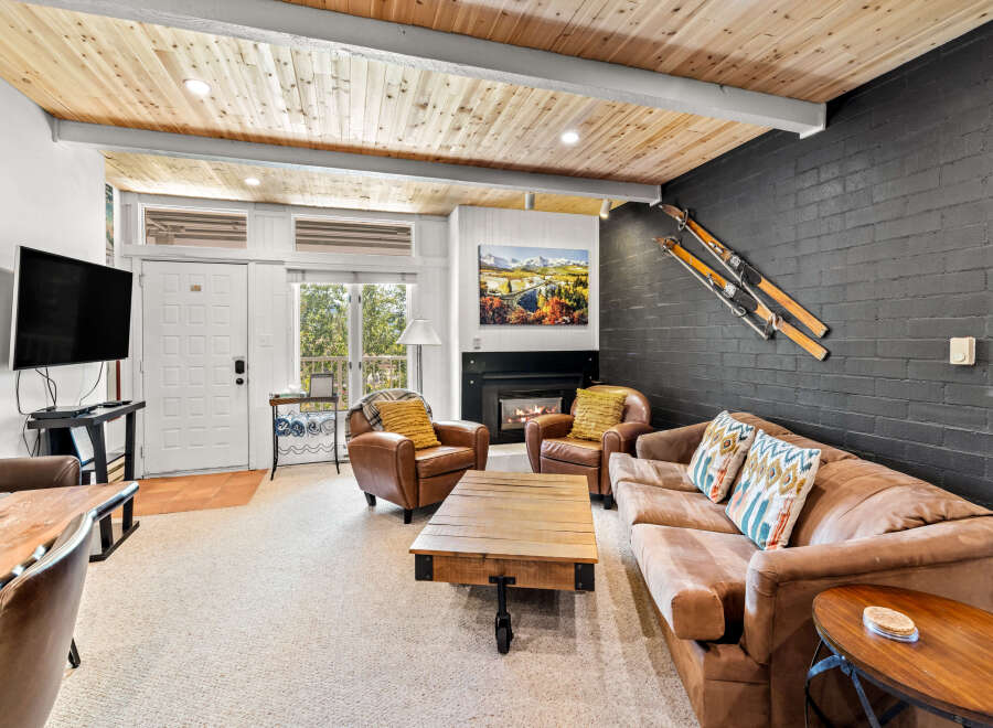 Experience cozy mountain living in this inviting living room, featuring a warm fireplace and comfortable leather seating.