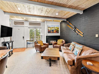 Experience cozy mountain living in this inviting living room, featuring a warm fireplace and comfortable leather seating.