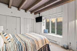 This cozy bedroom features a comfortable bed with striped linens, perfect for a relaxing getaway.