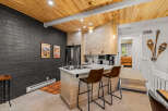Experience modern mountain living in this stylish kitchen featuring a sleek island with bar seating and a chic backsplash.