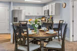 Enjoy meals in this charming dining area, featuring a rustic wooden table set for four and surrounded by elegant dark wood chairs.