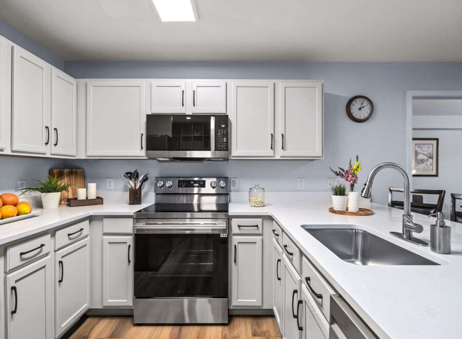 Discover this beautifully updated kitchen featuring sleek white cabinetry with modern black hardware.