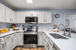 Discover this beautifully updated kitchen featuring sleek white cabinetry with modern black hardware.