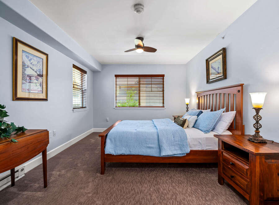 Experience comfort and style in this inviting bedroom, featuring a plush blue comforter on a sturdy wooden bed frame.