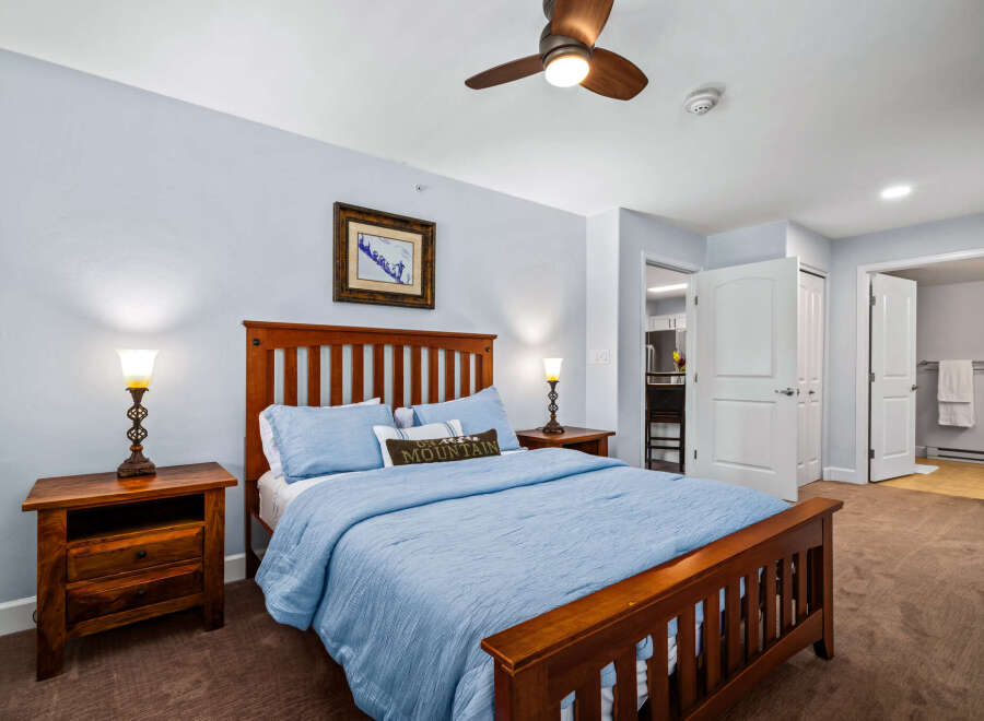 Experience comfort and style in this inviting bedroom, featuring a sturdy wooden bed frame and plush blue bedding.