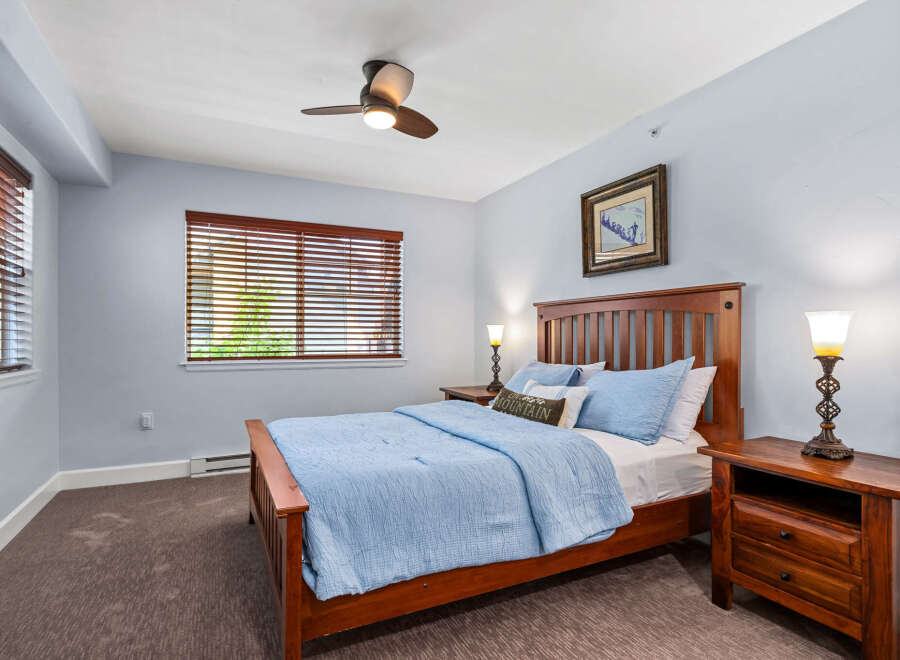This cozy bedroom features a comfortable queen-sized bed with a light blue comforter and matching pillows.