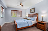 This cozy bedroom features a comfortable queen-sized bed with a light blue comforter and matching pillows.