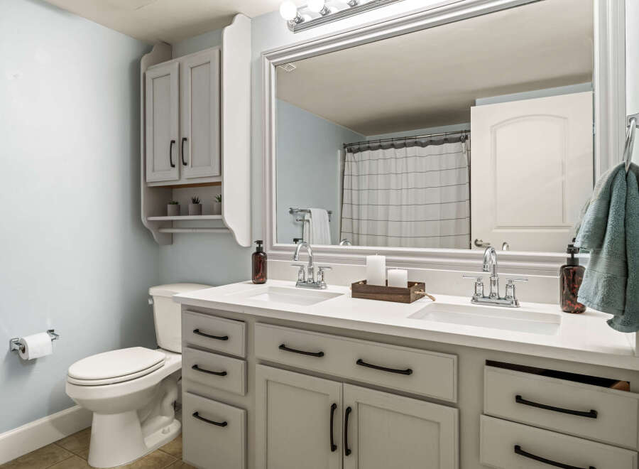 This bright and airy bathroom features a spacious double vanity with ample counter space and storage.
