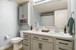 This bright and airy bathroom features a spacious double vanity with ample counter space and storage.
