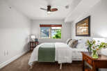 This inviting bedroom features a comfortable queen-size bed adorned with crisp white linens and a stylish green throw.