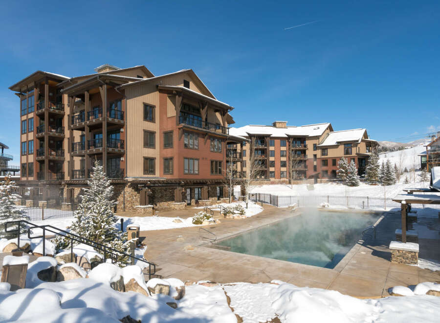 Experience luxury mountain living in this stunning condominium complex, featuring a steaming outdoor pool perfect for winter dips.
