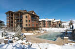 Experience luxury mountain living in this stunning condominium complex, featuring a steaming outdoor pool perfect for winter dips.