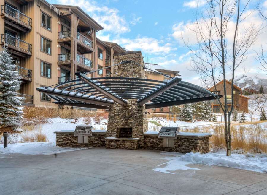 Experience outdoor living year-round with this stunning patio featuring a built-in stone fireplace and two premium grills, perfect for entertaining.
