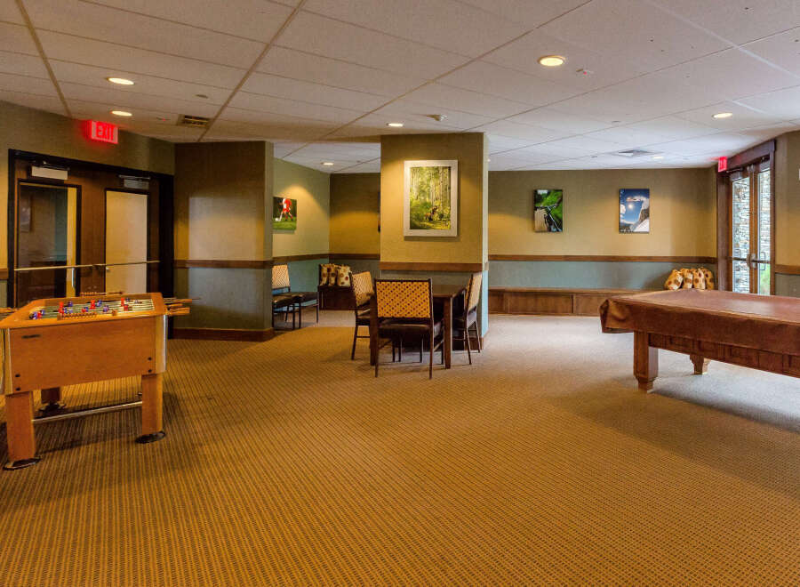 This versatile recreational space offers a foosball table and a billiards table, perfect for entertainment and leisure.
