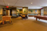 This versatile recreational space offers a foosball table and a billiards table, perfect for entertainment and leisure.