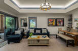 Experience modern living in this spacious living and dining area, featuring a comfortable navy blue sofa and a rustic wooden coffee table.