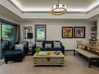 Experience modern living in this spacious living and dining area, featuring a comfortable navy blue sofa and a rustic wooden coffee table.