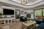 Experience comfort and style in this inviting living room, featuring a large flat-screen TV, a cozy fireplace, and ample seating.