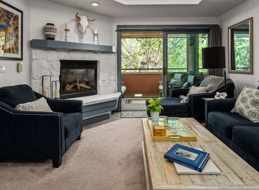 Cozy living room featuring a stone fireplace and comfortable navy blue seating.
