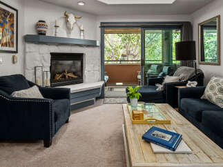 Cozy living room featuring a stone fireplace and comfortable navy blue seating.