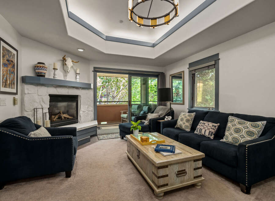 Experience cozy living in this inviting living room, featuring a striking stone fireplace and a comfortable navy blue sofa.
