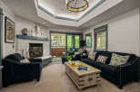 Experience cozy living in this inviting living room, featuring a striking stone fireplace and a comfortable navy blue sofa.