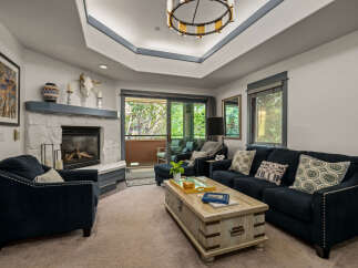 Experience cozy living in this inviting living room, featuring a striking stone fireplace and a comfortable navy blue sofa.