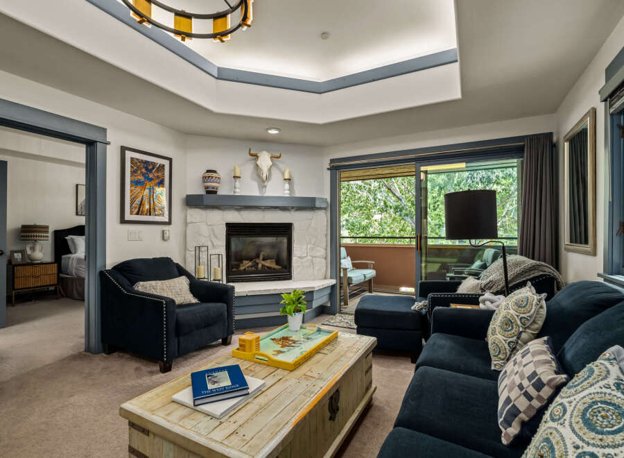 Step into this inviting living room, featuring a cozy stone fireplace and comfortable seating perfect for relaxation.