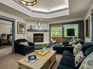 Step into this inviting living room, featuring a cozy stone fireplace and comfortable seating perfect for relaxation.