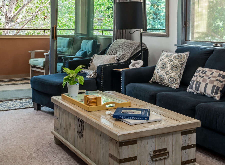 Step into this inviting living room, featuring a plush navy sectional sofa and a rustic wooden coffee table perfect for gatherings.