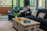 Step into this inviting living room, featuring a plush navy sectional sofa and a rustic wooden coffee table perfect for gatherings.