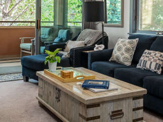 Step into this inviting living room, featuring a plush navy sectional sofa and a rustic wooden coffee table perfect for gatherings.