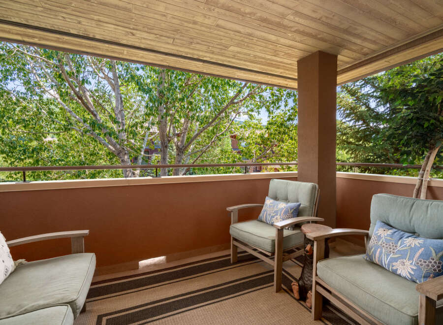 Enjoy the outdoors from this charming balcony, perfect for relaxing with a view of lush greenery.