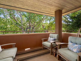 Enjoy the outdoors from this charming balcony, perfect for relaxing with a view of lush greenery.