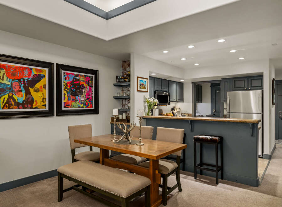 This open-concept living space features a modern dining area with a wooden table and upholstered seating, perfect for family meals.