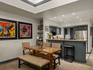This open-concept living space features a modern dining area with a wooden table and upholstered seating, perfect for family meals.