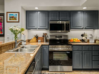 This modern kitchen features sleek, dark gray cabinetry complemented by a stunning granite countertop.